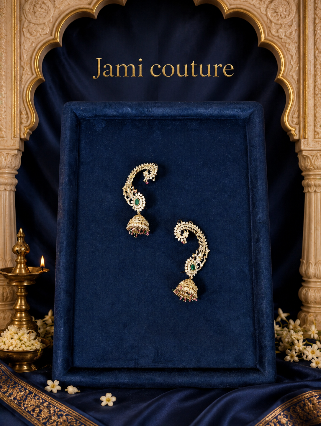 Antique gold peacock ear cuff earrings laid on a navy velvet tray in a gold frame