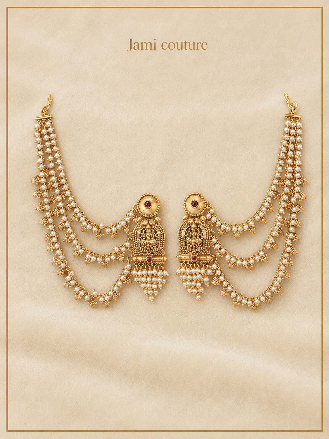 Pair of antique gold Lakshmi jhumka earrings with layered pearl chains, laid flat
