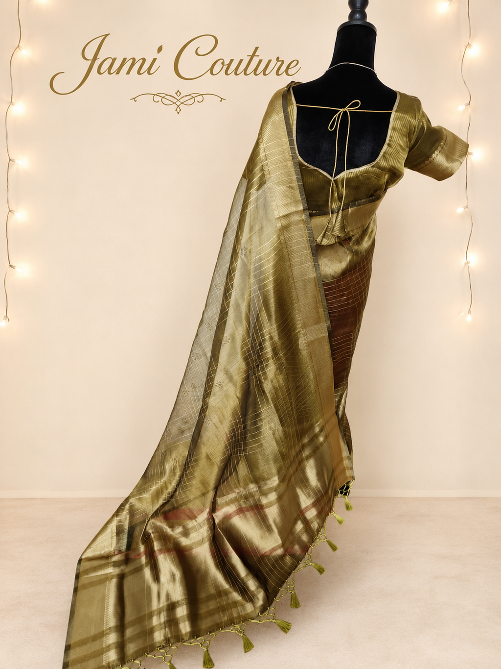 Back view of the antique gold tissue organza saree with the tasseled pallu falling to the floor