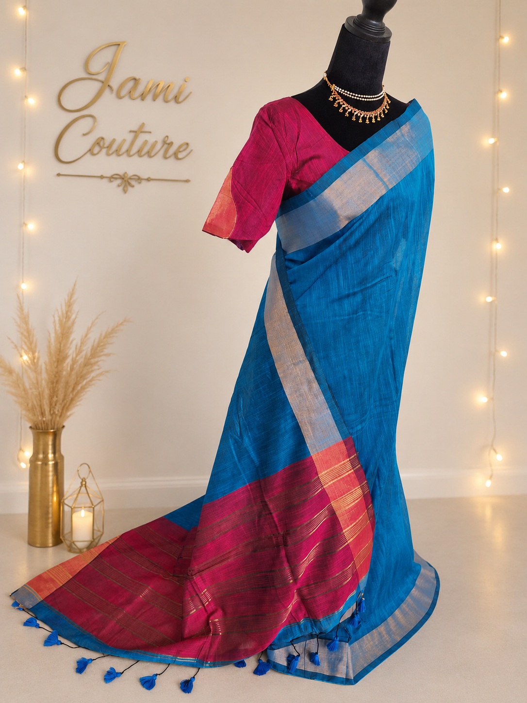 Three-quarter view of the blue khadi cotton saree showing the pink and gold striped pallu with tassels