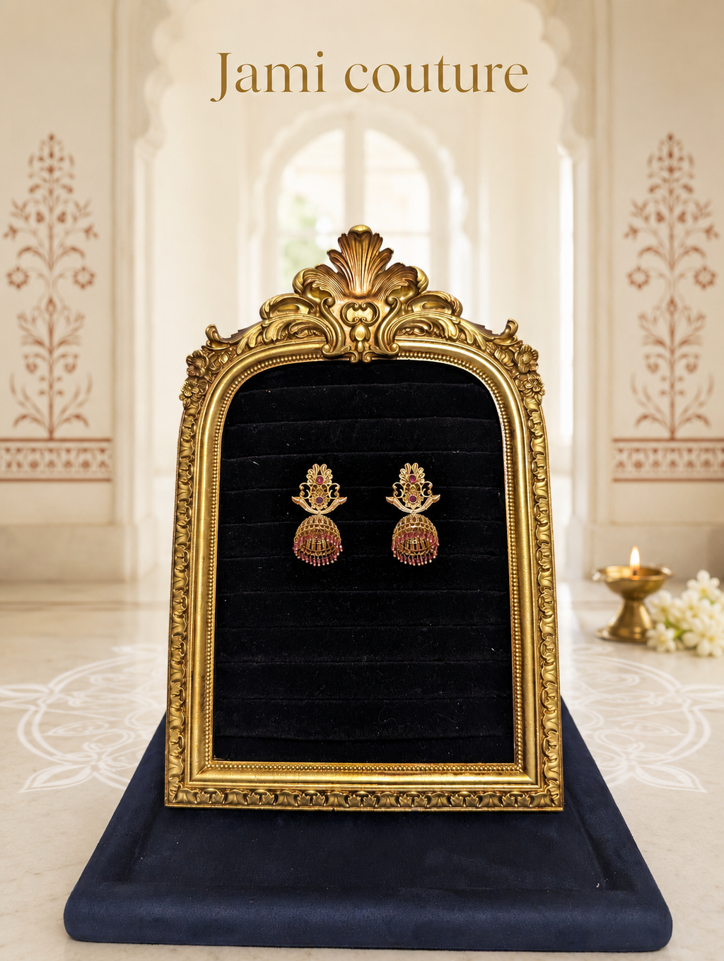 Antique gold floral jhumka earrings with ruby stones displayed on black velvet in a gold frame