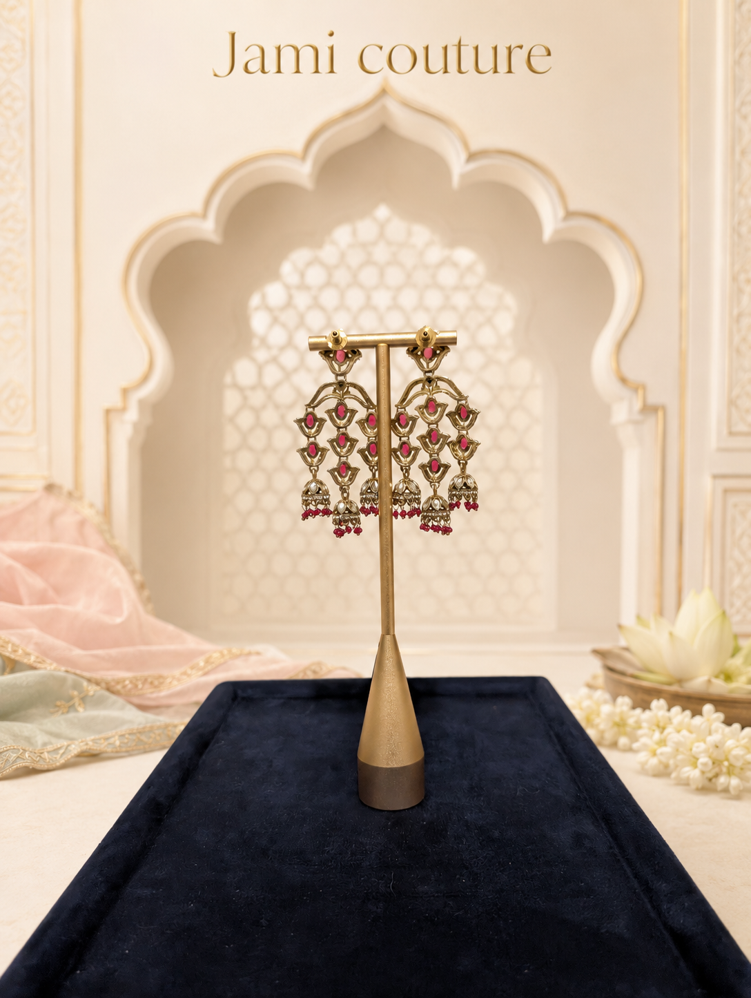 Close view of the rani pink triple jhumka chandelier earrings on a stand