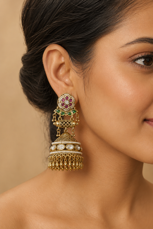 Model wearing an antique gold kundan jhumka earring with pearl fringe, profile view
