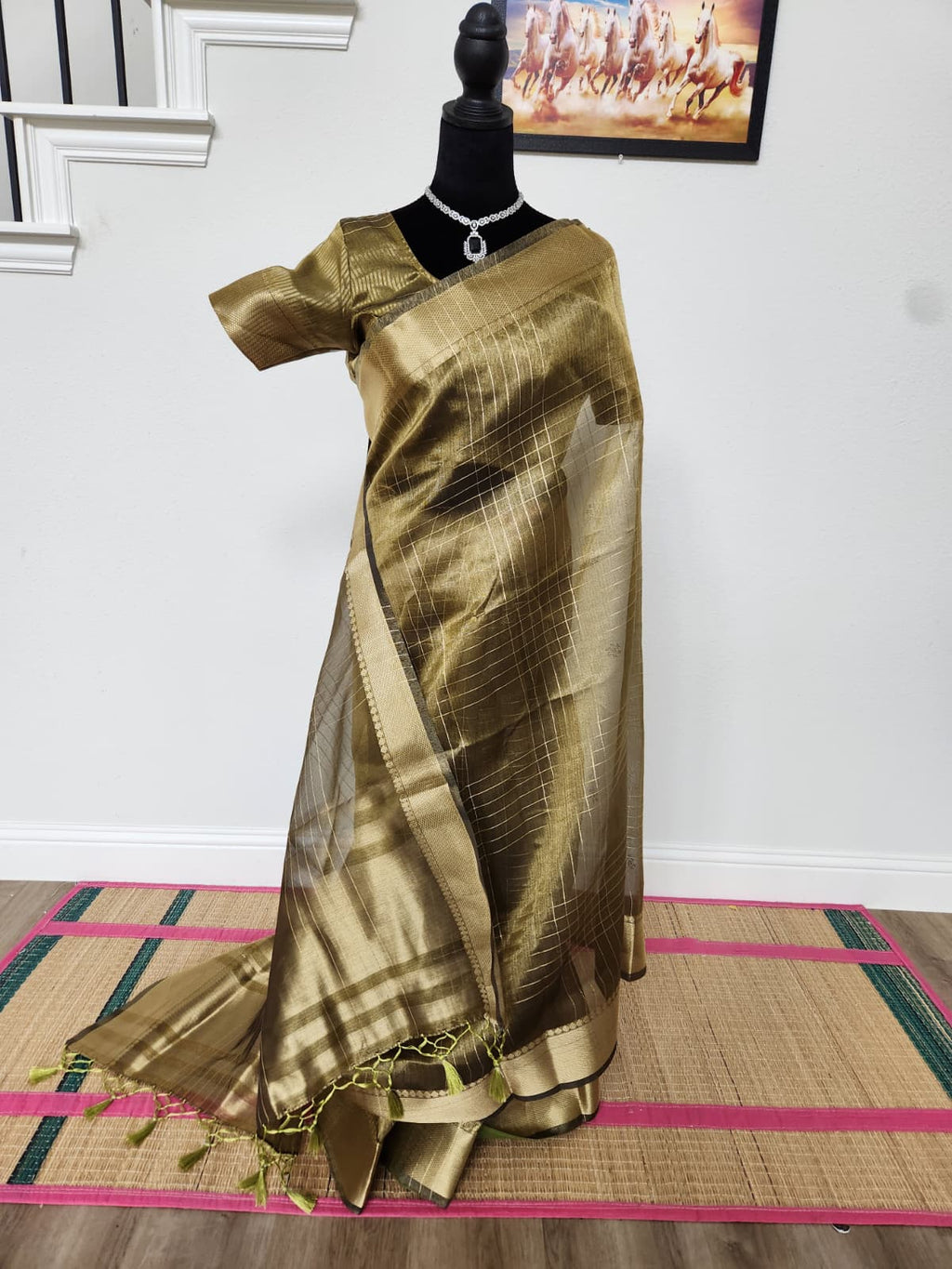 Natural-light front view of the olive-gold tissue organza saree with zari checks and tassels