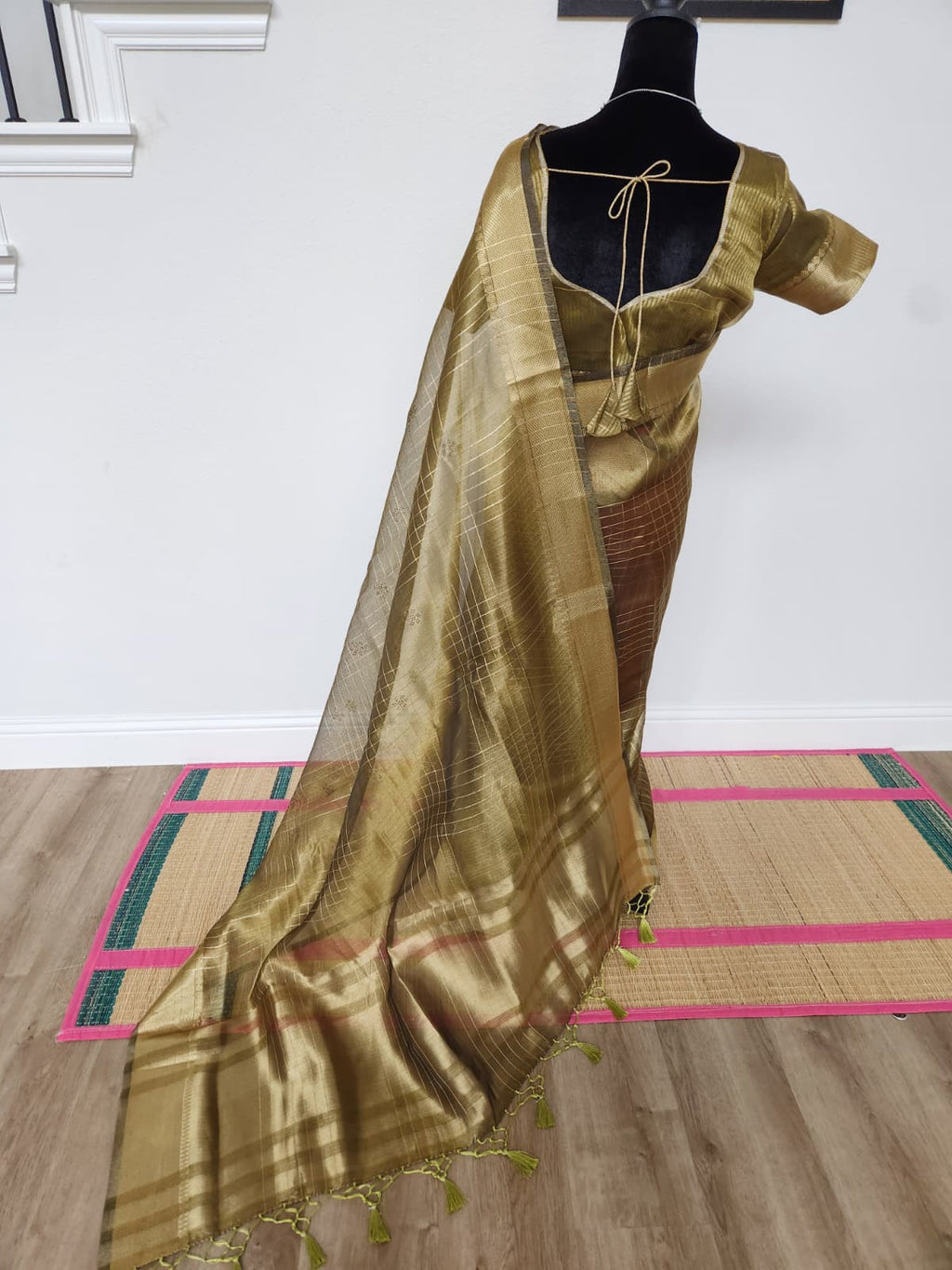 Natural-light back view of the antique gold organza saree with the sheer pallu spread out