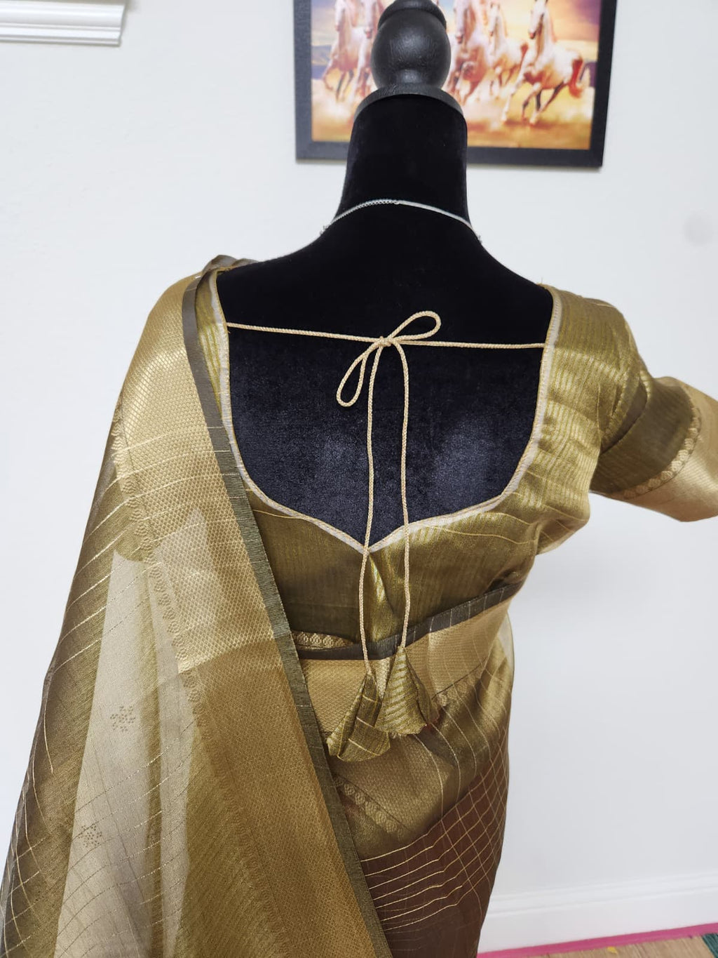 Natural-light close-up of the blouse back with tie closure and the sheer zari-checked pallu