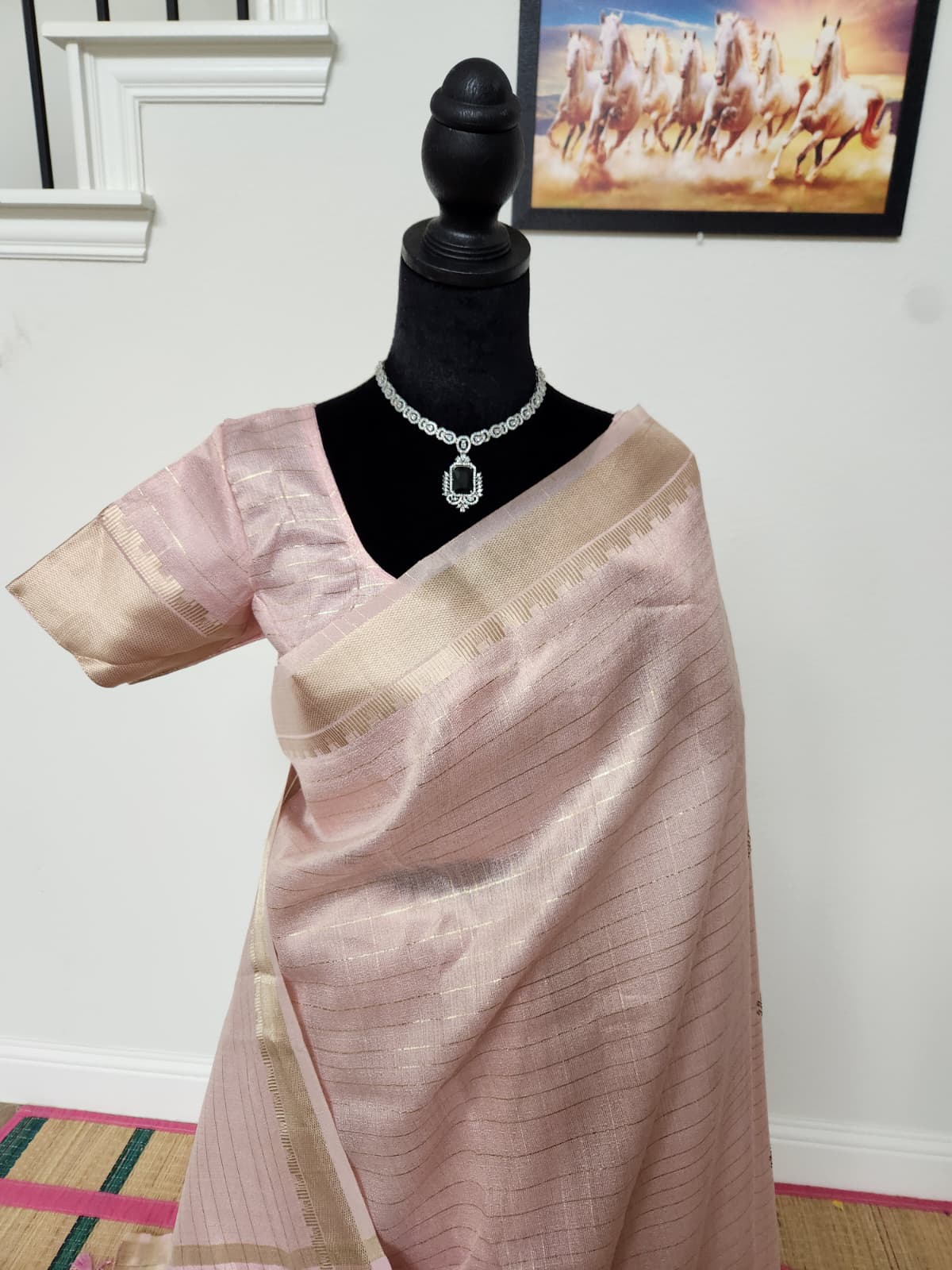Natural-light close-up of the front showing gold zari checks on the baby pink body and the zari-bordered blouse sleeve