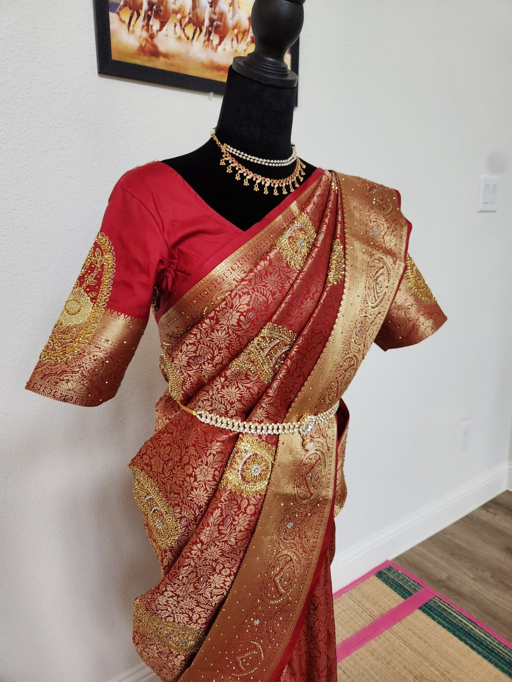 Natural-light close view of the red and gold zardosi saree drape and pallu over the shoulder