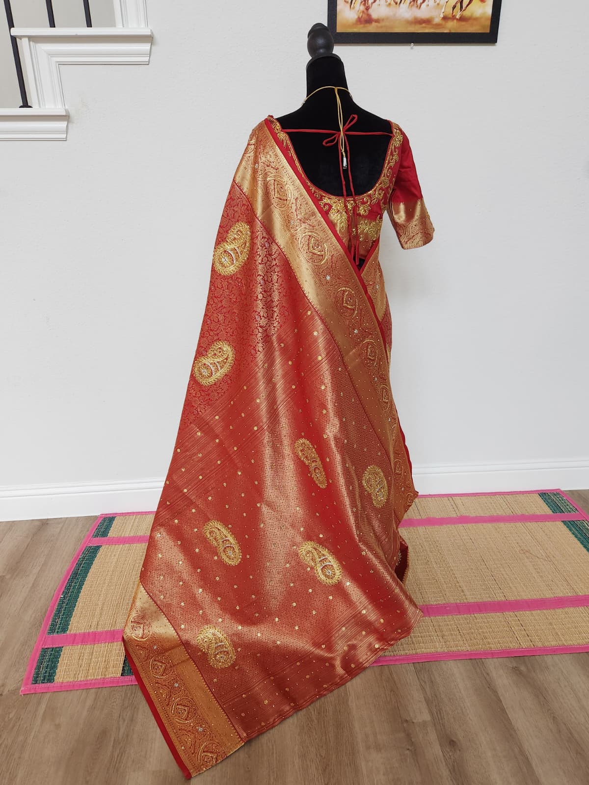 Natural-light back view of the red semi silk saree with gold paisley zardosi pallu