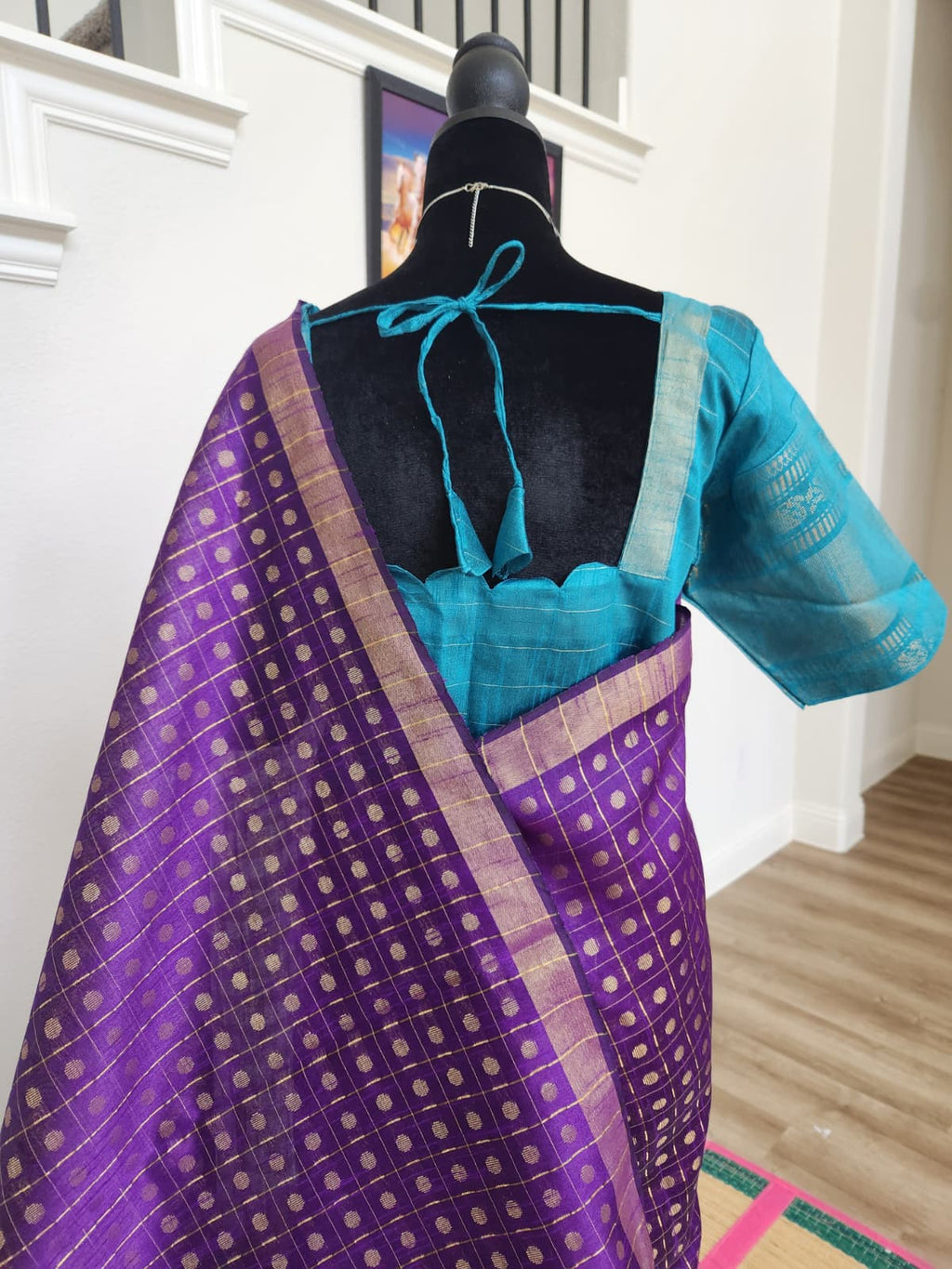Natural-light close-up of the teal blouse back with tie closure and the purple butta pallu