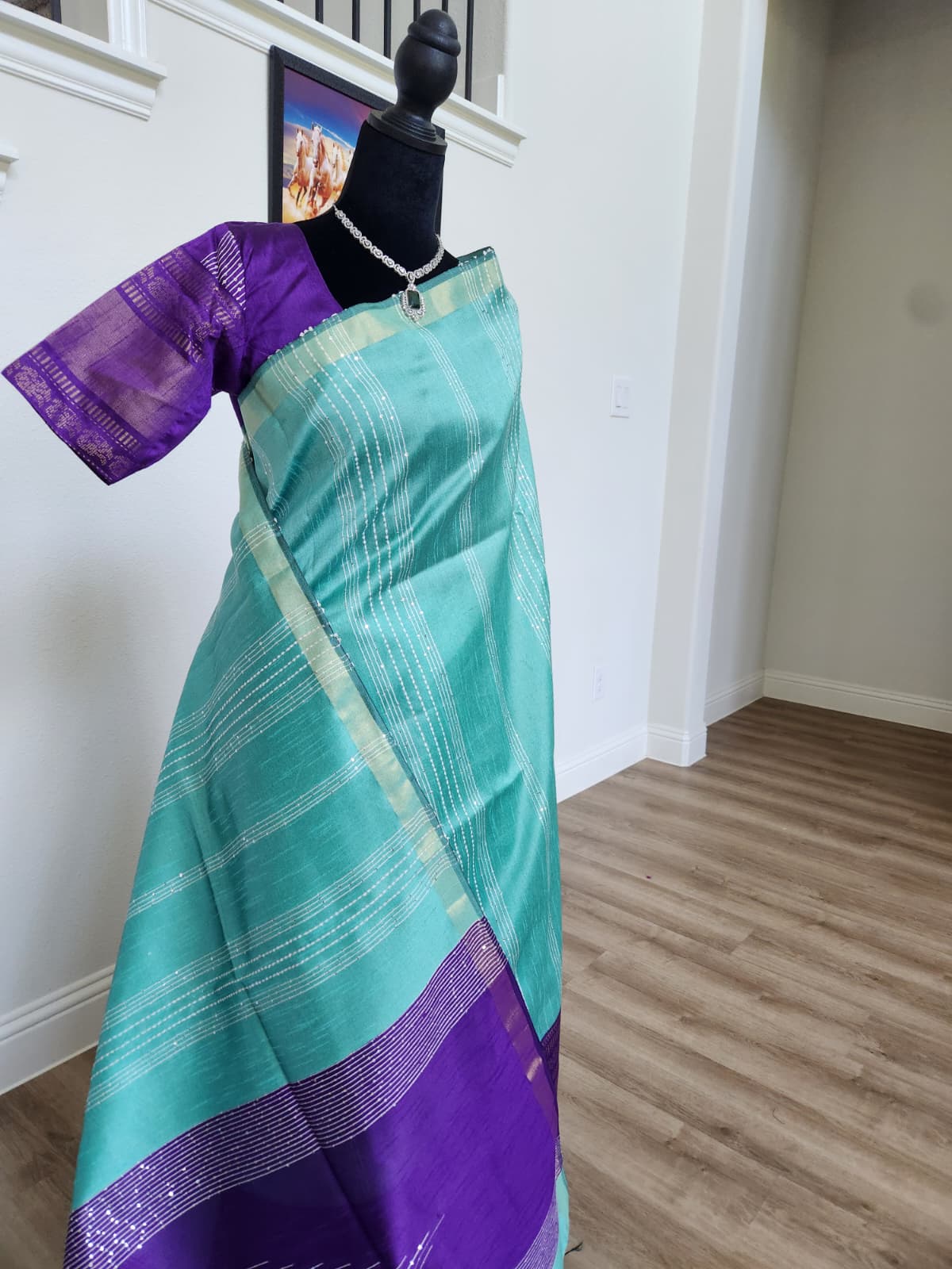 Natural-light three-quarter view of the turquoise and royal purple color-block saree