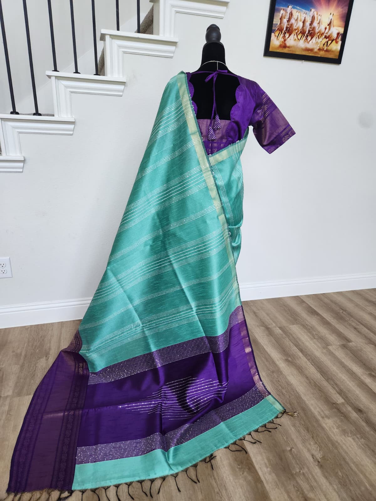 Natural-light back view of the turquoise saree with the purple-bordered pallu