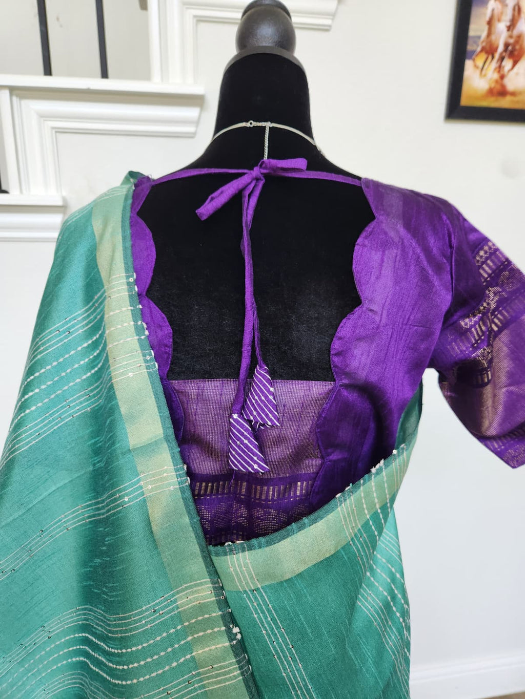 Natural-light close-up of the purple blouse back with scalloped cut-out and tie closure