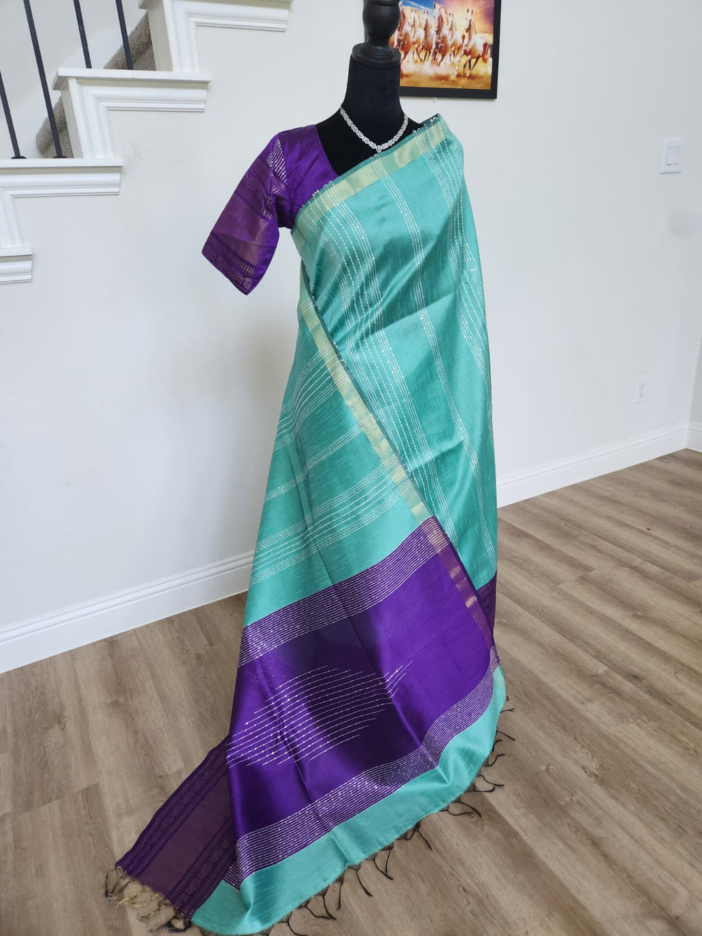 Natural-light full-length view of the turquoise and royal purple silk saree with tassels