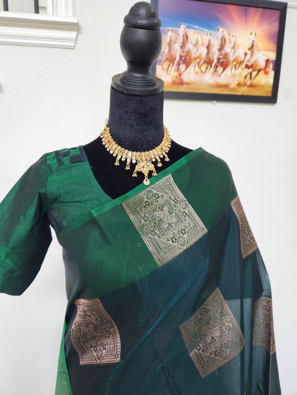Natural-light close-up of the matching blouse and gold zari brocade buttis on the bottle green body