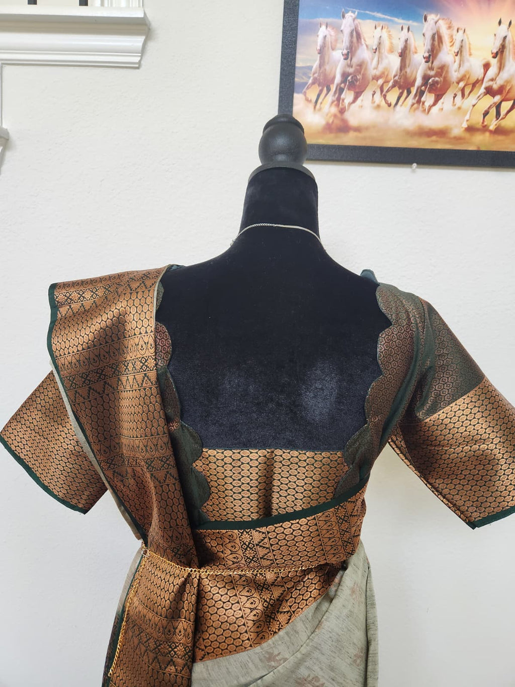 Natural-light close-up of the blouse back with scalloped cut-out and copper zari pallu