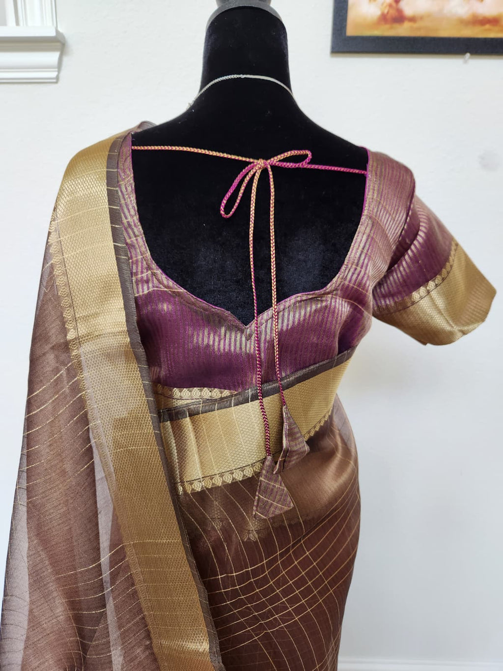 Natural-light close-up of the wine blouse back with tie closure and the zari-checked pallu